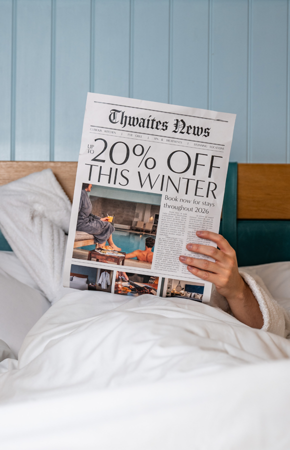 "up to 20% off this winter" newspaper being read in a hotel bed